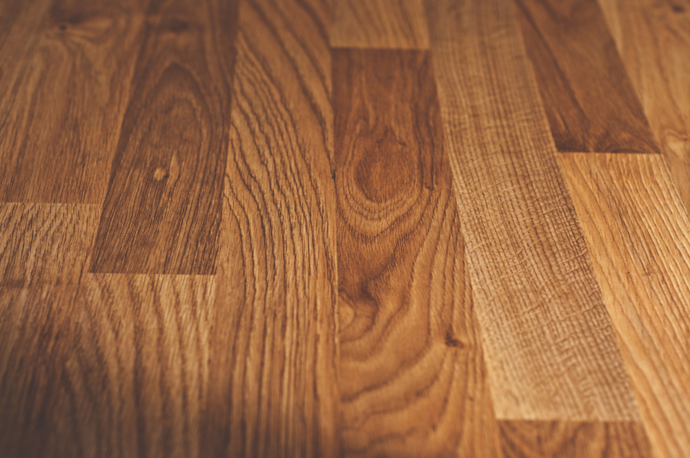 Suelo de madera natural en tono cálido, con veteado visible y acabado mate